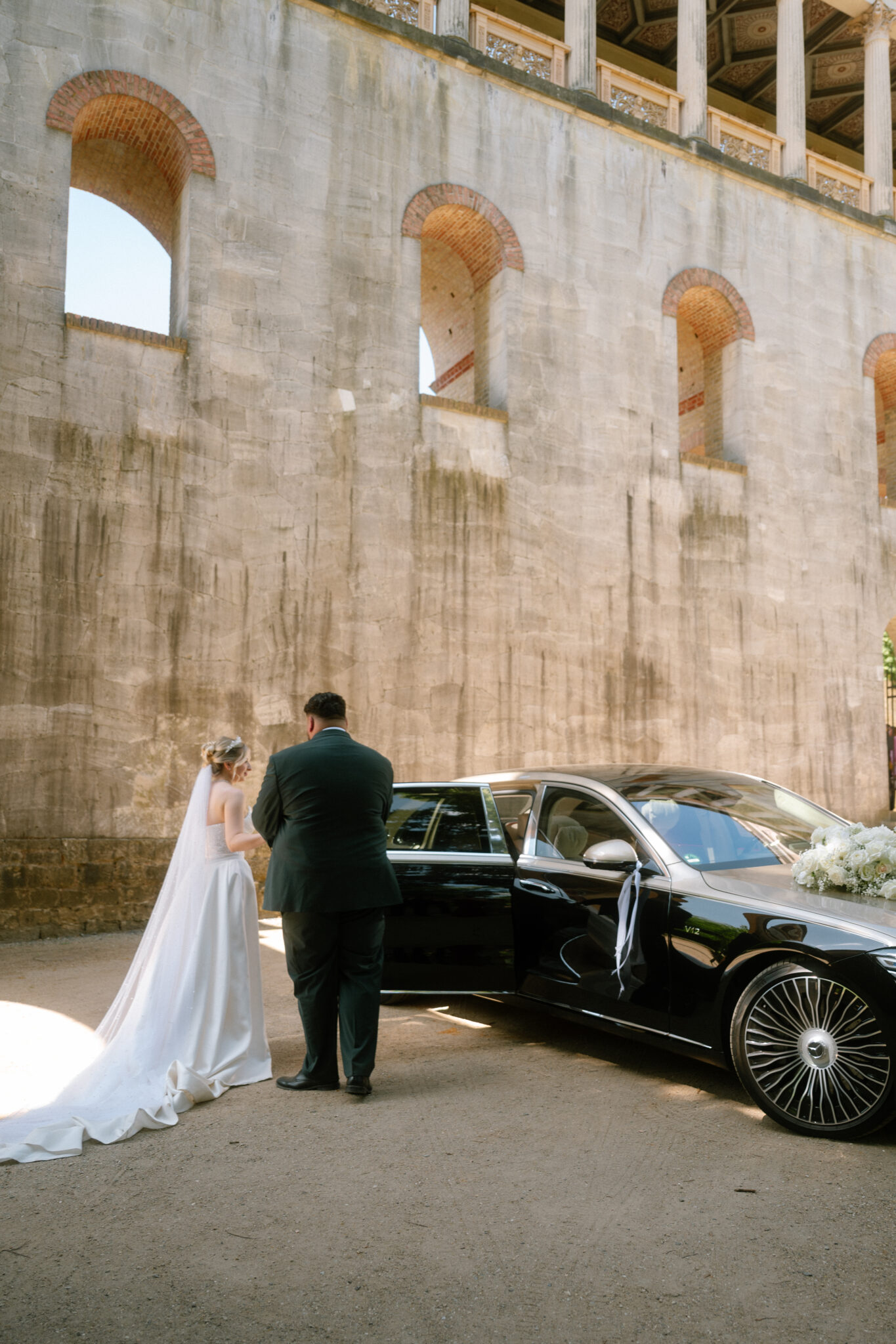Brautpaar nach Trauung am Auto in Hochzeitslocation in Berlin